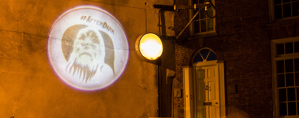 Creative Advertising student work - logo projected on a wall at night