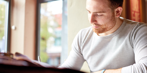 A male student sat working at a desk