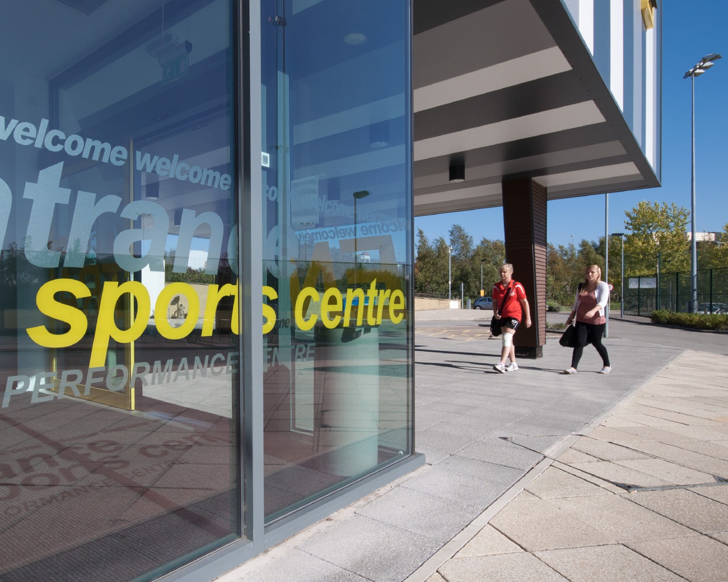 Two people walking towards the Sports Centre